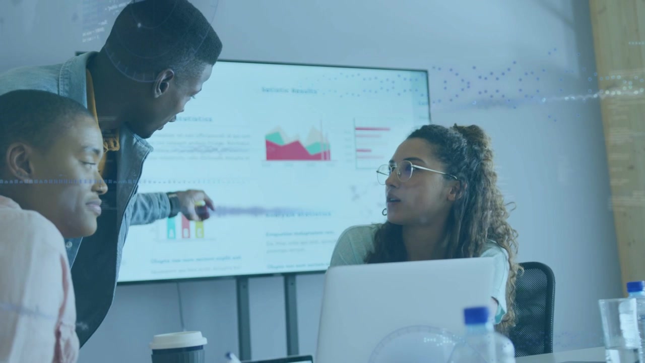 Man leaning and pointing at laptop, woman explaining charts, initiating data overlays for business