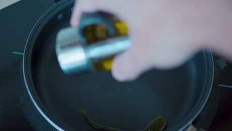 Pouring-olive-oil-into-a-frying-pan-for-cooking