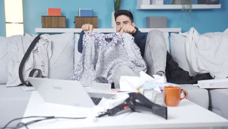 messy young man at home packing his things and watching movie.