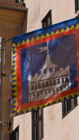 flag flapping in the wind. walls of the old castle of bran at backdrop. dracula home place in romania. vertical video