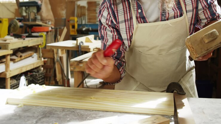 Carpenter using hammer and chisel