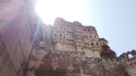 Glorious-Tracking-Shot-Revealing-Sun-Behind-City-Walls-at-Mehrangarh-Fort-at-Jodhpur,-Rajasthan,-India