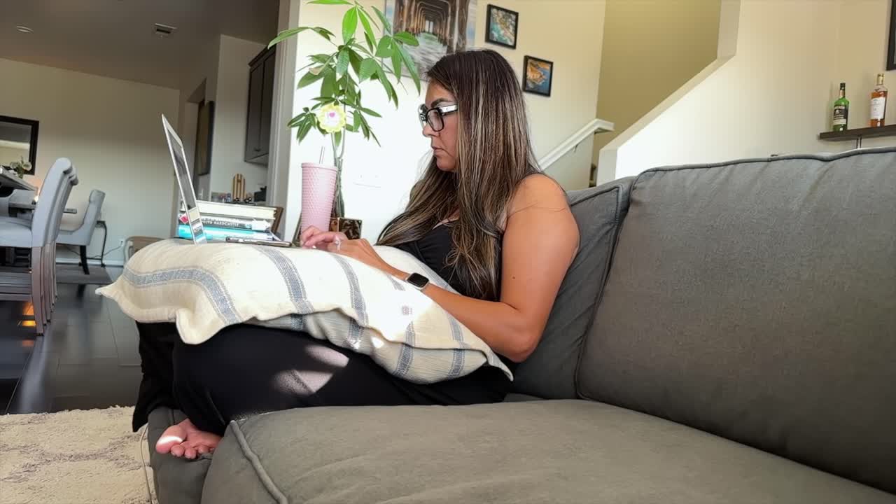 mujer latina atractiva trabajando en una computadora portátil relajándose en casa