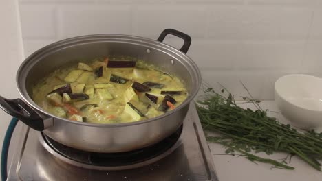 an authentic traditional filipino dish called ginataang gulay or coconut milk vegetable stew simmering in a pot showing the candid moment of daily home cooking and lifestyle in the philippines