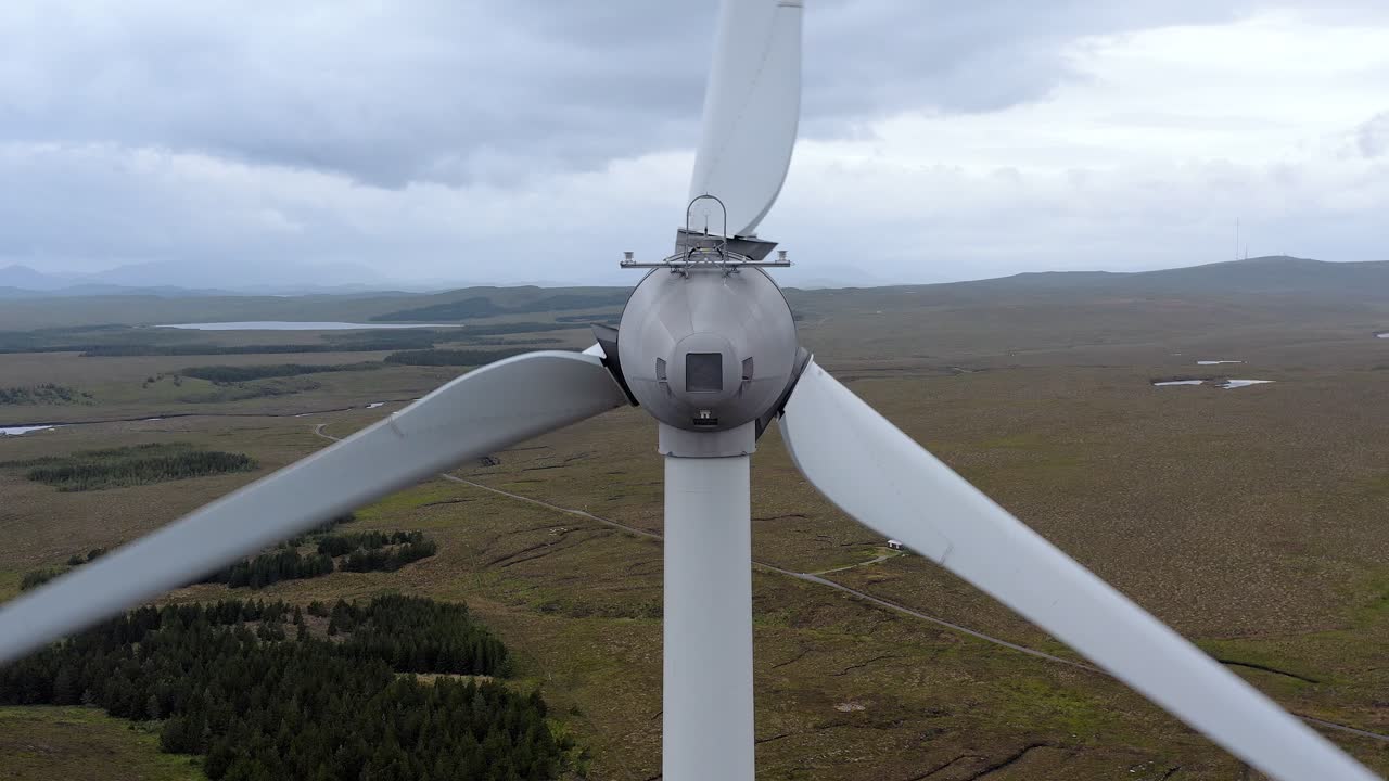 Close up drone shot dari motor turbin angin di ladang angin di Hebrides