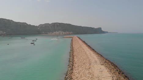 Aerial-shot-of-blue-sea-and-rock-path-way-in-between-the-sea