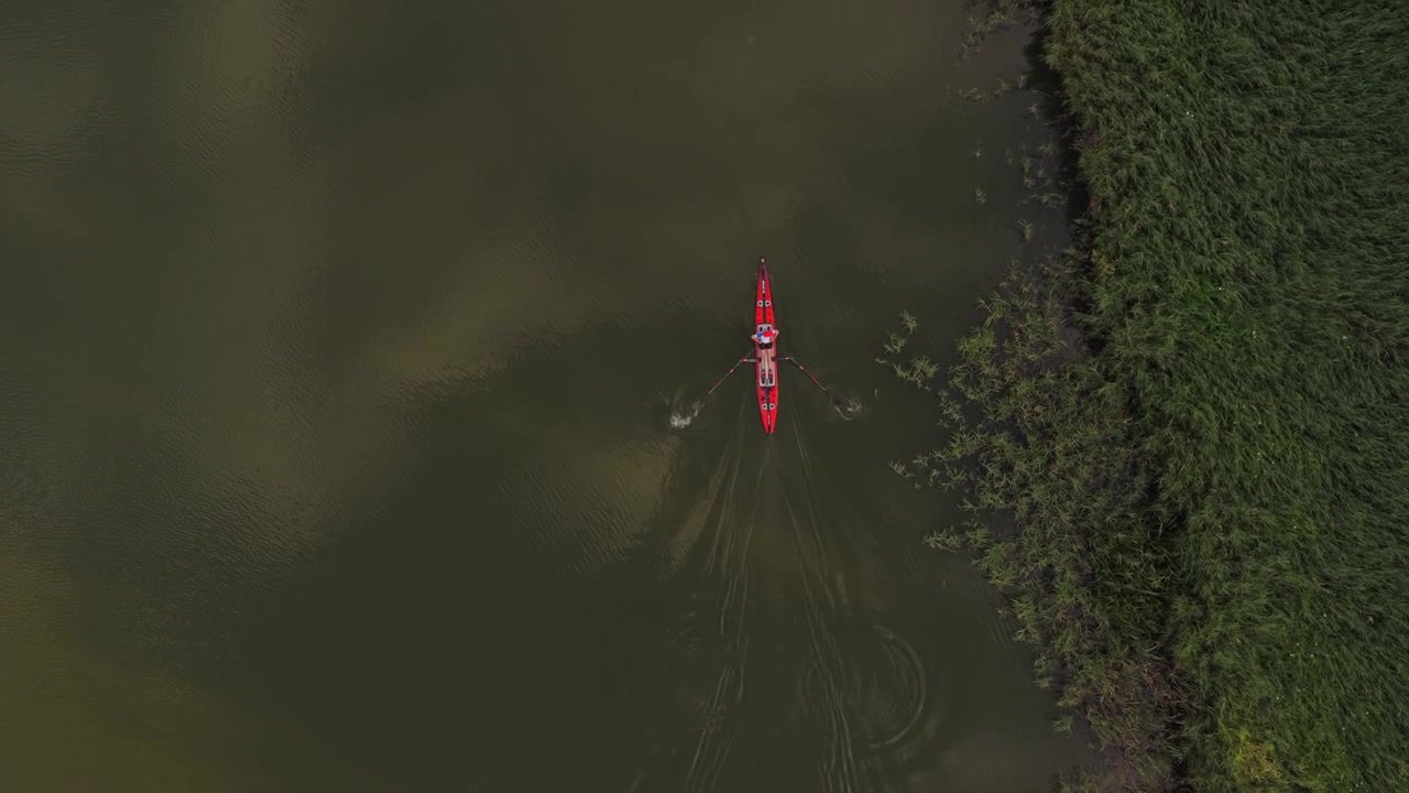 Aerial View of a Person Rowing a Red Kayak on a Calm River
