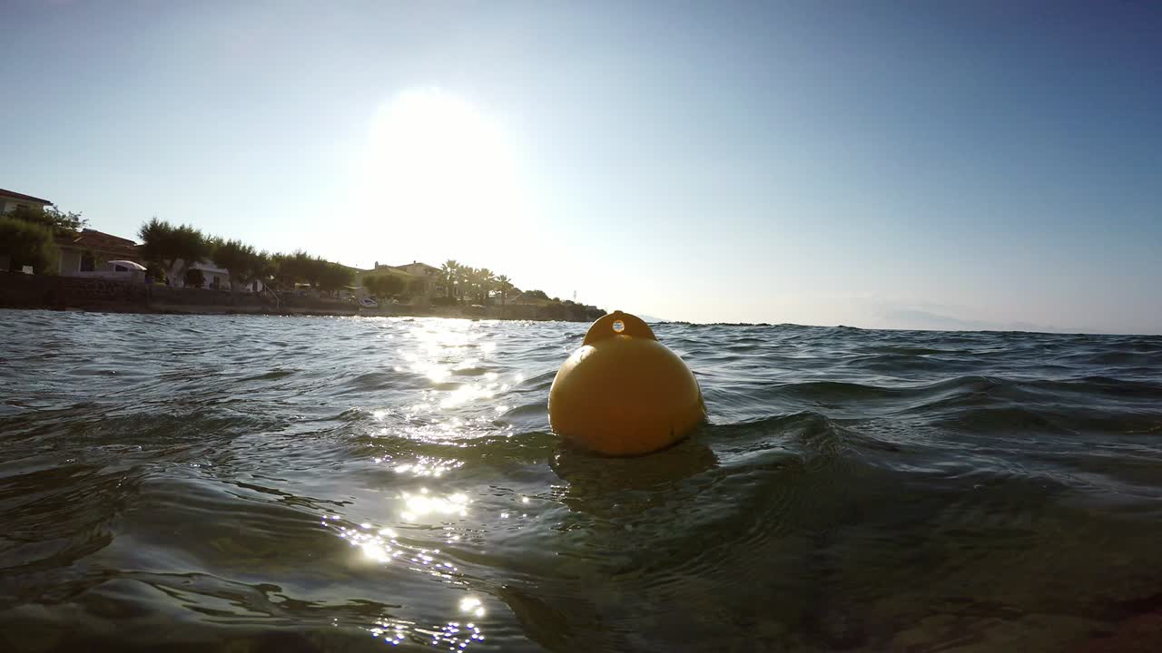 노란색 보이가 바다의 파도에서 흔들리고 있습니다.