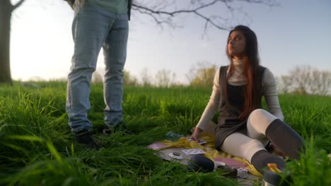 couple relaxing and playing cards in park