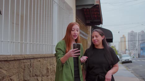 two women walking and engaging with a smartphone video call