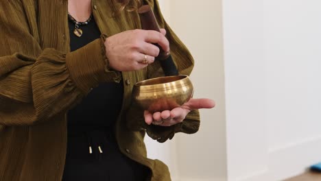 sound therapist using tibetan singing bowl creating vibration healing.