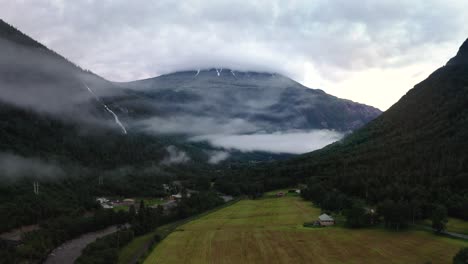 vast meadow next to river in misty vestfjord valley, rjukan, norway