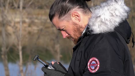 caucasian man pilots a drone from his remote control, he is focused on his video feedback