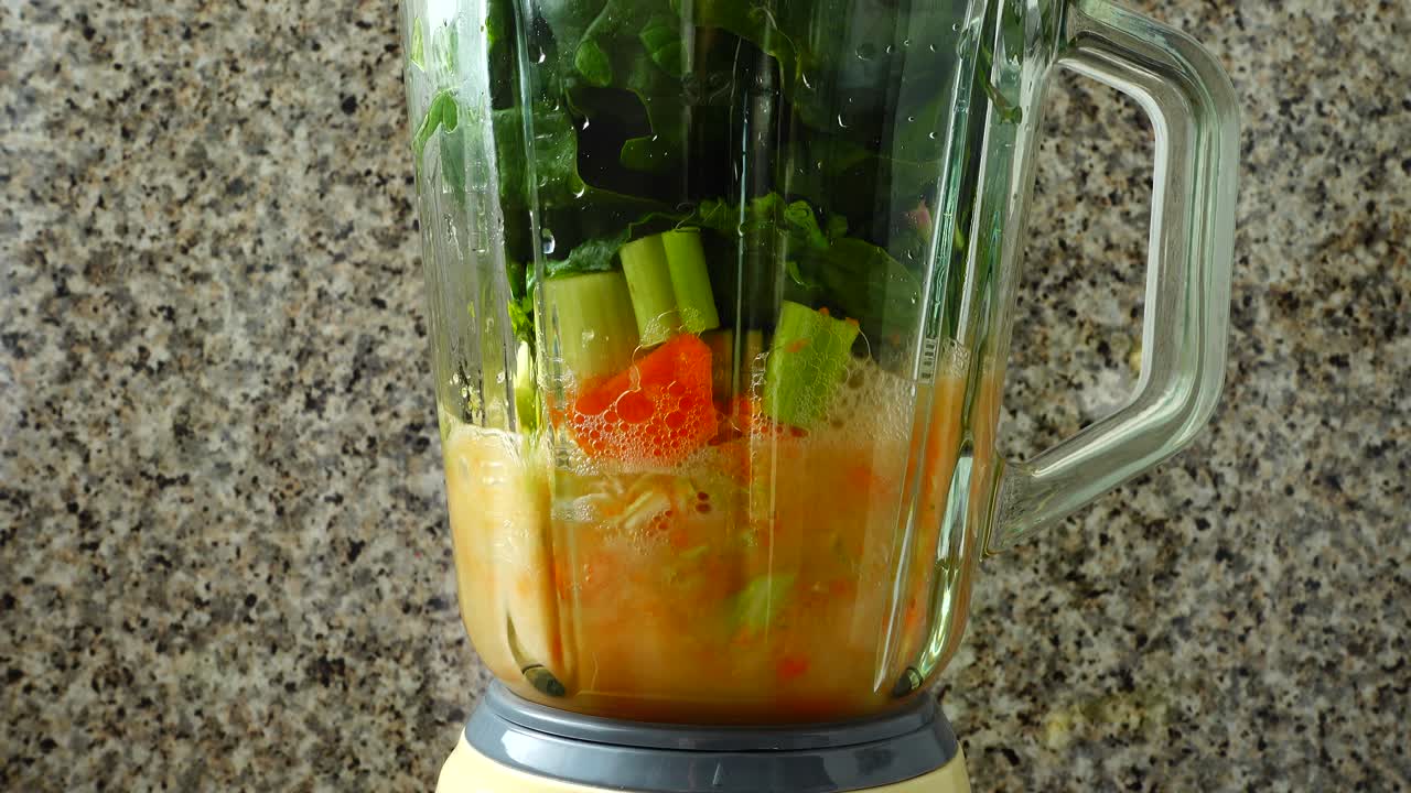 Cocktail di carote, un gambo di sedano e spinaci. Preparazione del cocktail.