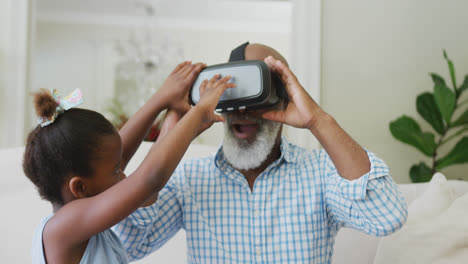 Feliz-Abuelo-Afroamericano-Usando-Auriculares-Vr-Con-Su-Nieta-En-La-Sala-De-Estar