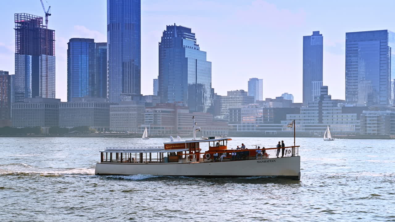 Few people travel by the long riverboat. Diverse modern hazy skyline of New York at backdrop