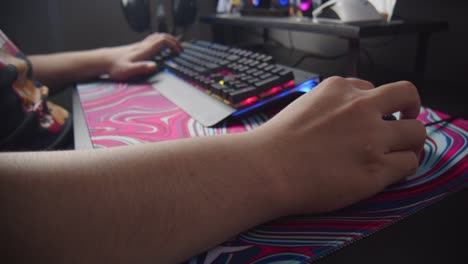 Close-up-of-asian-hands-clicking-gaming-keyboard-and-mouse-while-playing-esport