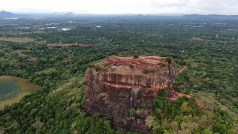 Vista-Aérea-De-La-Fortaleza-De-Roca-De-Sigiriya-En-Sri-Lanka-Rodeada-De-Selva-Verde-Y-Colinas-Montañosas-En-El-Fondo