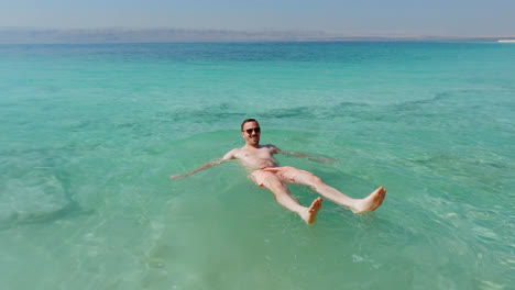 Happy-Tourist-Lays-Down-in-Dead-Sea-and-Floats-Easily