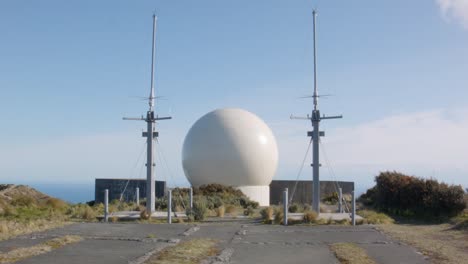 una cúpula de radar con antena en la cima de una colina