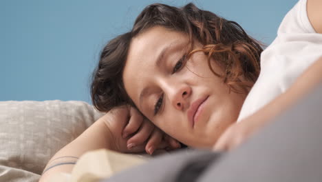woman reading a book lying on the living room couch
