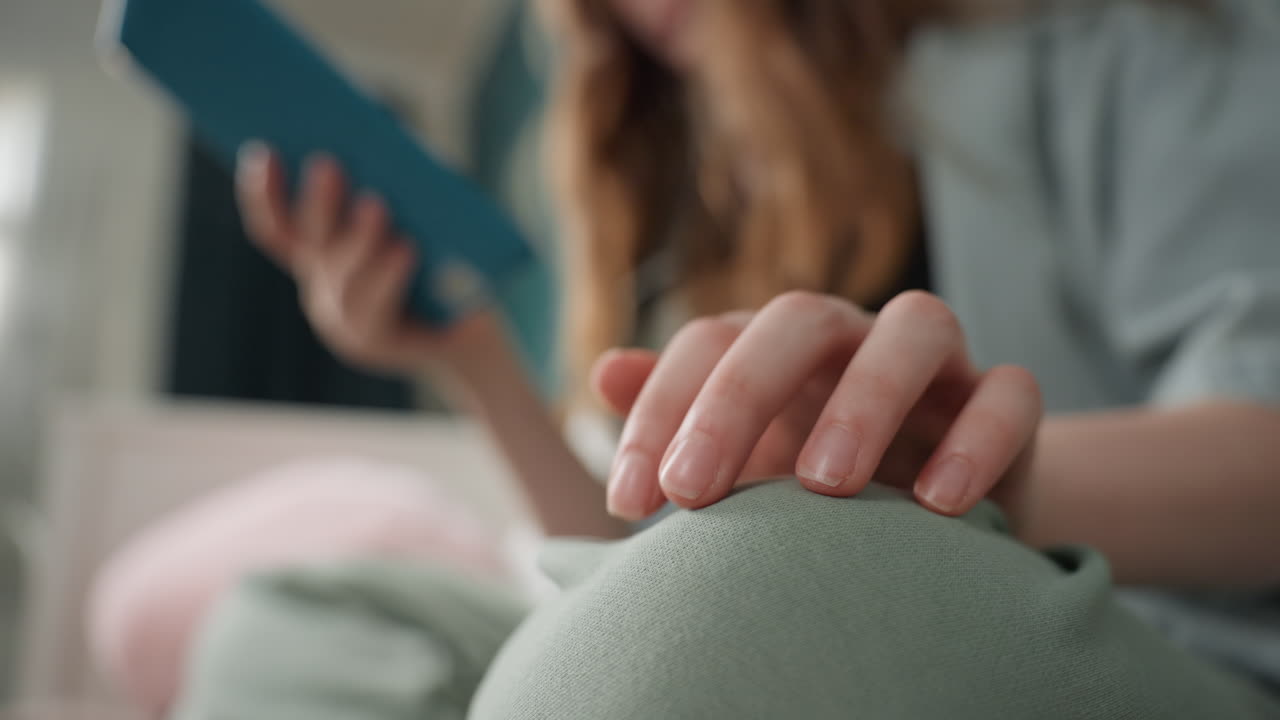 Hånd på pude. Afslappet hånd på plysset pude. Nærbillede af hånd, der hviler på blød pude med sløret baggrund. Detaljeret skud af hånd, der ligger på hyggelig pude med ufokuseret baggrund.
