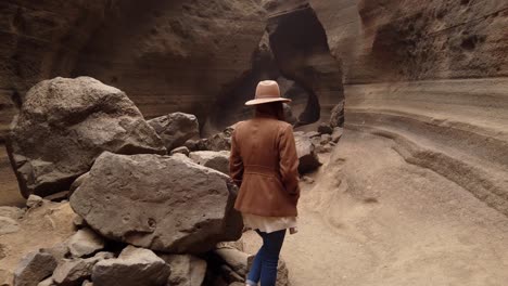 mujer caminando dentro en el barranco con grandes piedras "