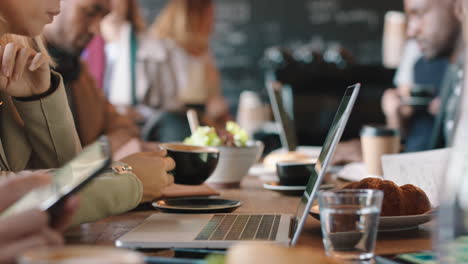 business woman hands using laptop computer in cafe typing emails working online enjoying drinking coffee relaxing on lunch in busy restaurant