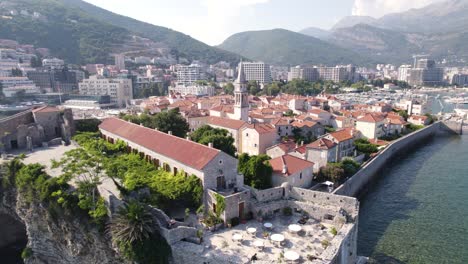 Aerial:-Sveti-Ivan-Church,-Budva-Citadel,-Montenegro's-coastal-beauty