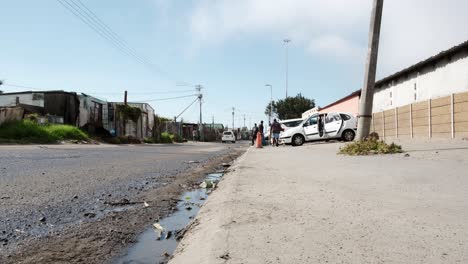 a wide low angle of a car wash operation in the streets of gugulethu, cape town