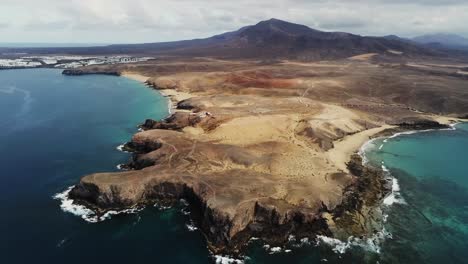 Majestuoso-Paisaje-Con-Montaña-En-El-Horizonte-En-La-Isla-De-Lanzarote,-Vista-Aérea