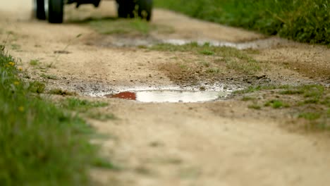 Atv-Rast-Eine-Strecke-Hinunter-Und-Spritzt-In-Eine-Pfütze