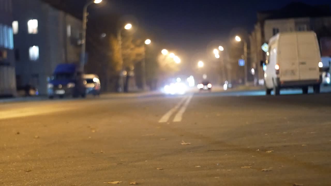 bokeh con tráfico callejero nocturno de la ciudad. coches y autobuses a la luz de faros y linternas