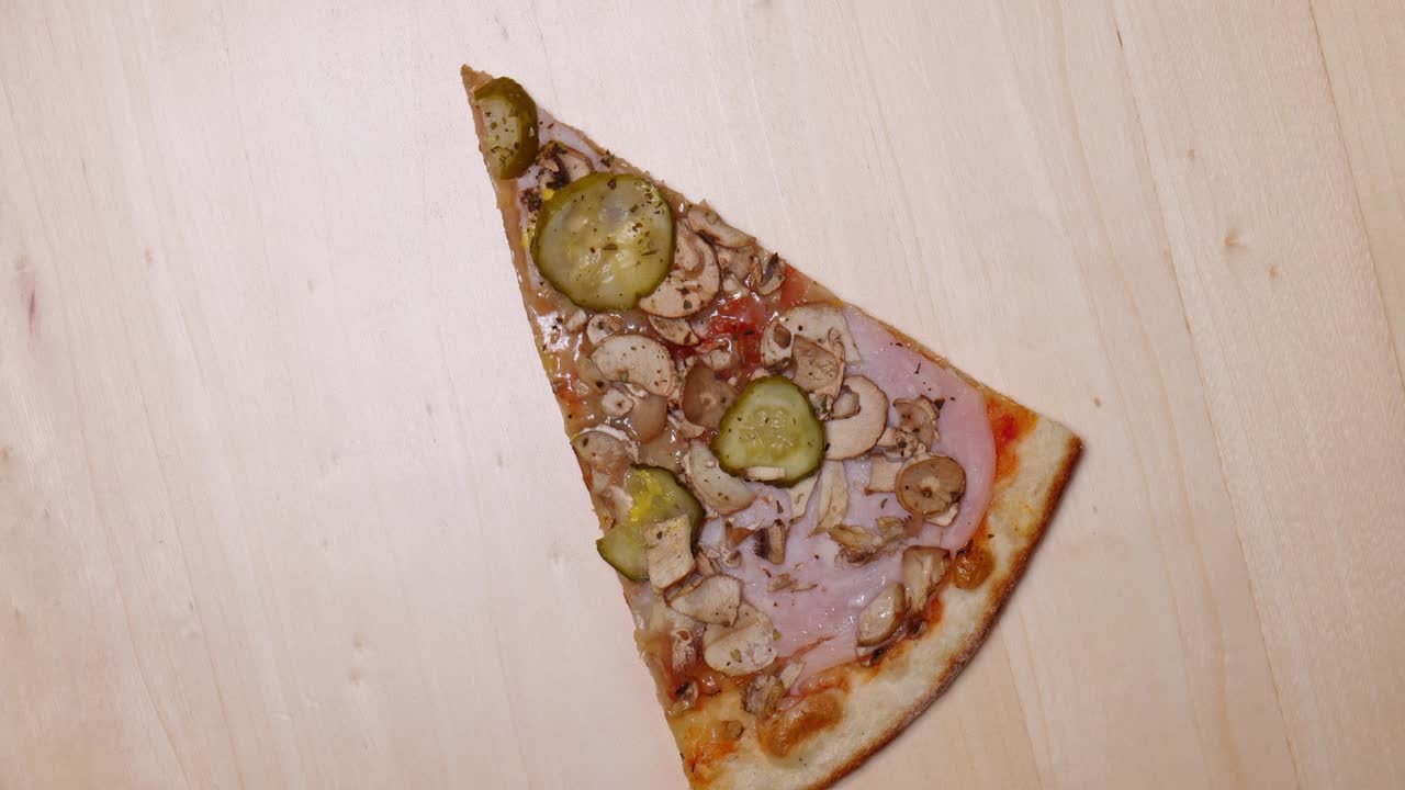 Pizza vista dall'alto. Rotazione di una fetta di pizza in primo piano.