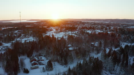 Sunset-aerial-drone-view-flying-over-a-snowy-residential-community-with-a-cell-base-tower