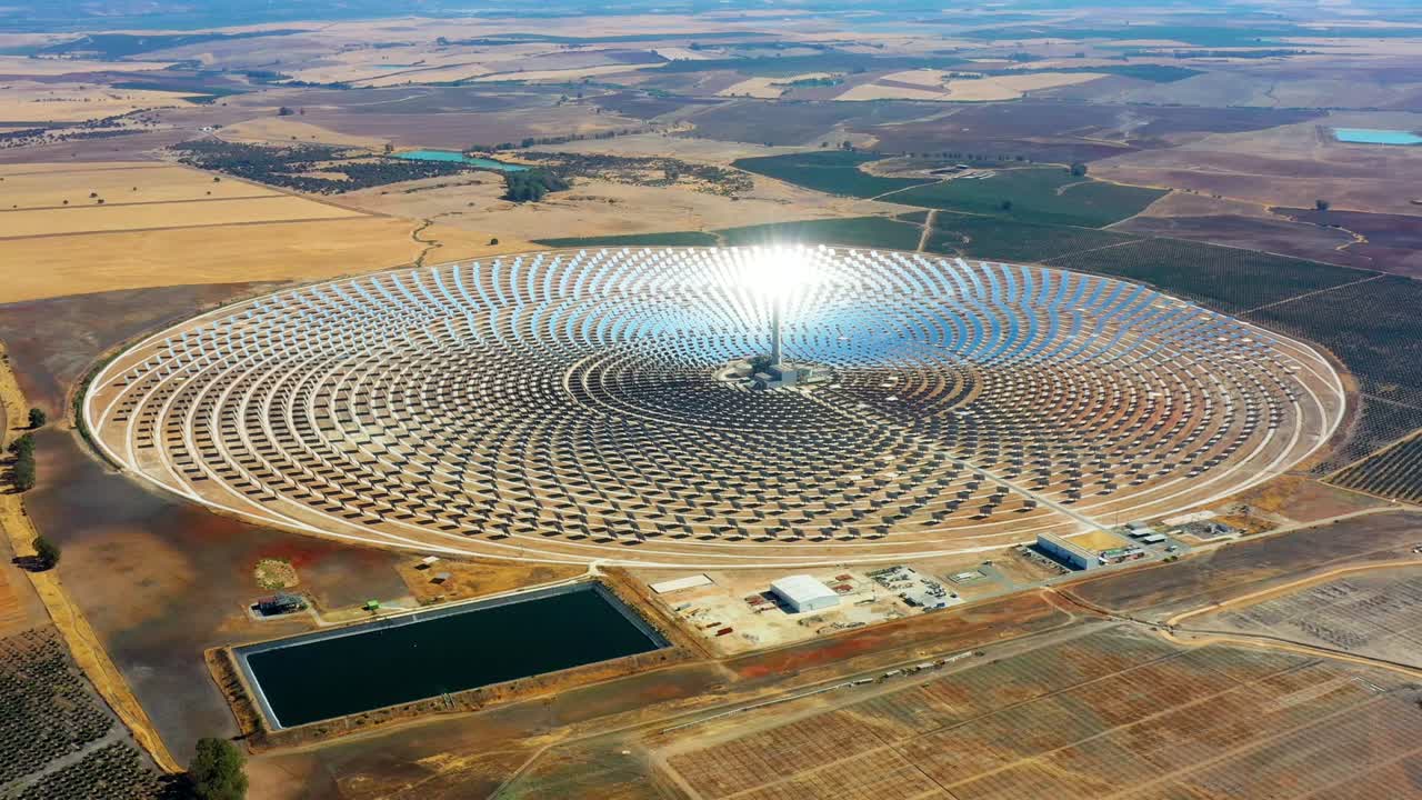 스페인에 있는 태양 전지판의 큰 원형 발전소의 공중 사진 - 재생 가능한 에너지를 생산하는 패널에서 태양의 반사 - 환경 개념