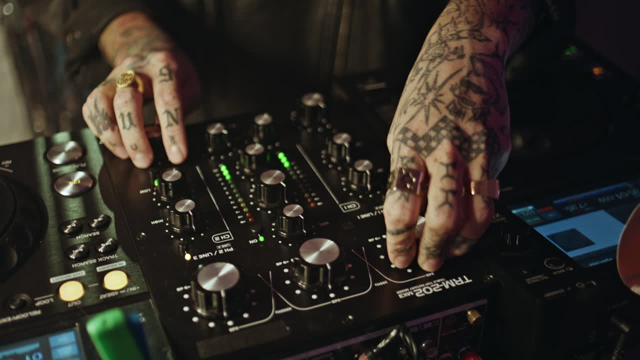 Happy DJ controlling mixer in neon disco club closeup. Woman focused on music