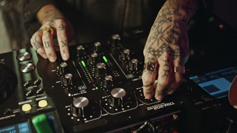 happy dj controlling mixer in neon disco club closeup. woman focused on music