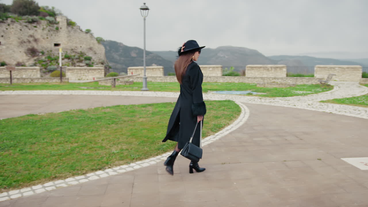 Woman Walking In The Middle Of The Small Town Park