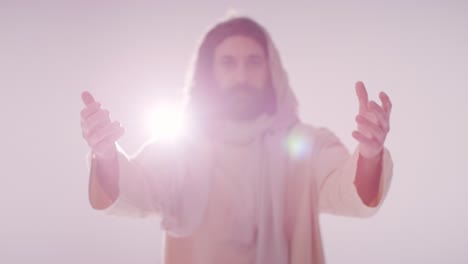 retrato retroiluminado de un hombre vestido con túnicas con cabello largo y barba que representa la figura de jesucristo orando o predicando