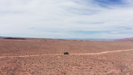 aéreo, van life autocaravana conduciendo por una carretera roja seca del desierto en arizona