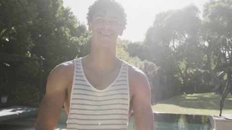 retrato de un feliz hombre biracial con gafas en el jardín en un día soleado