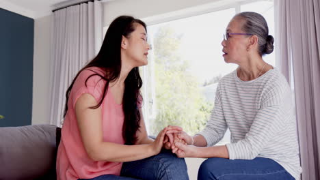 holding hands, asian grandmother and granddaughter having heartfelt conversation in school