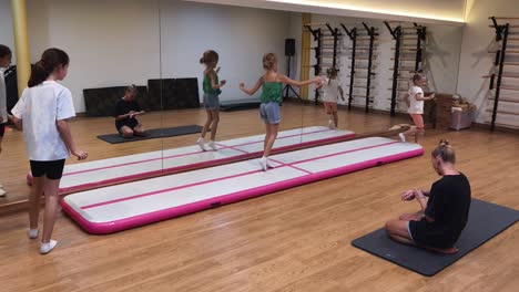 kids gymnastics training session on an inflatable air track