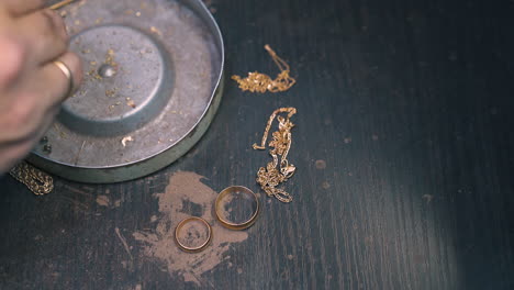 jeweler takes off rings chains and parts from box closeup