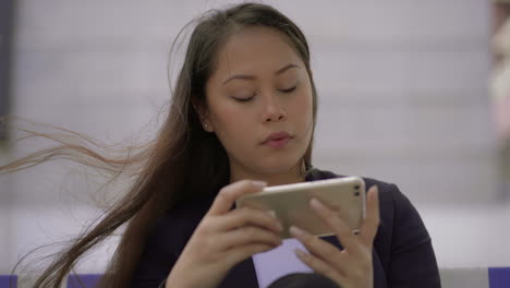 pensive young woman using smartphone outdoor