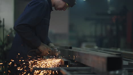 trabajador moliendo una hoja de metal. mecánico profesional está cortando metal de acero. trabajador de acero moliendo metal en cámara lenta trabajos economía de mano de obra