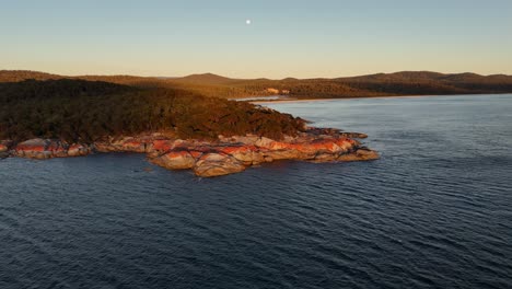 slow-motion shot of fires bay, iconic orange colored granite rocks, tasmania at sunset, australia