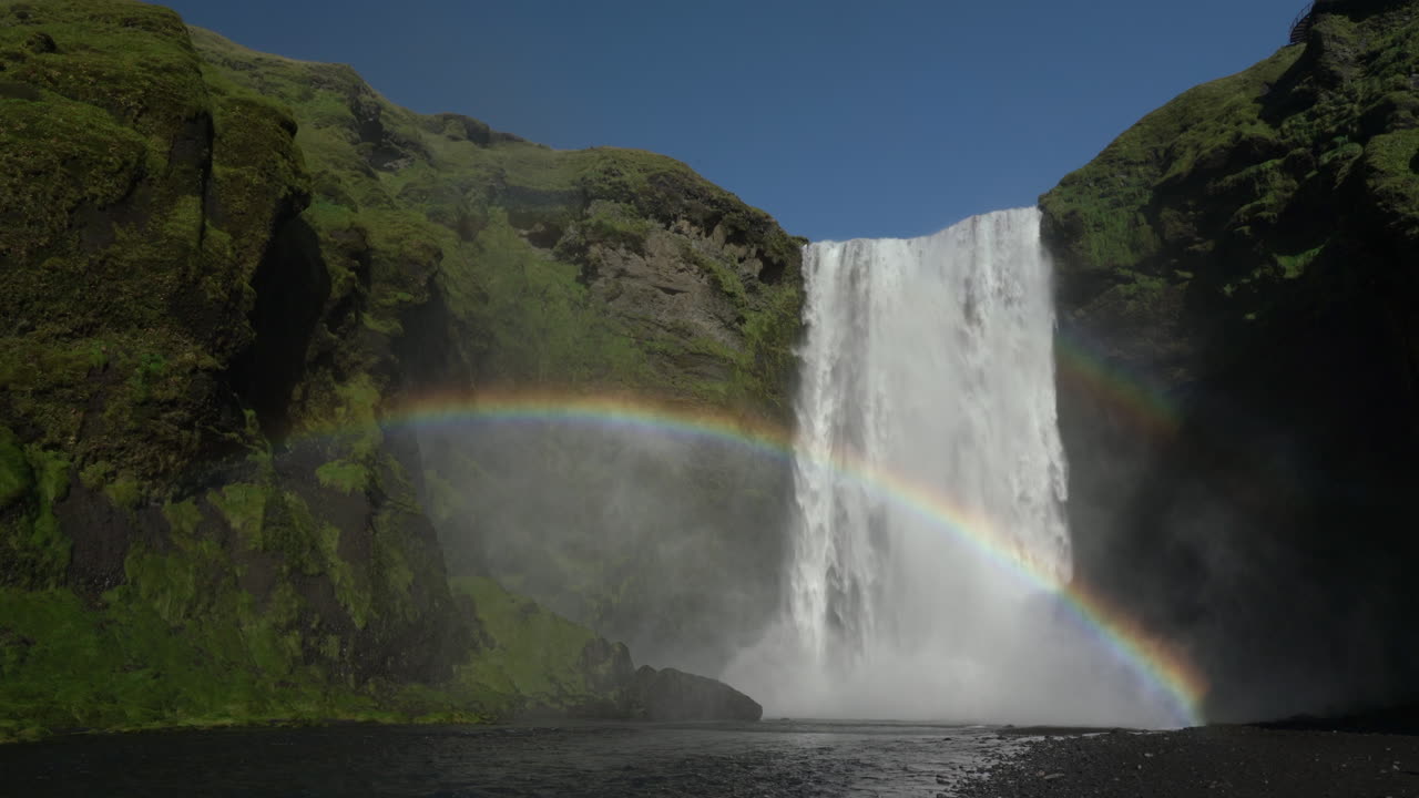 vista espectacular de cascadas espumosas que fluyen desde acantilados escarpados con arco iris doble