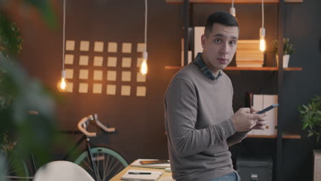man using smartphone in modern office environment